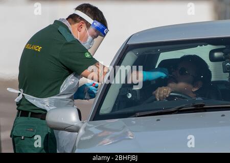 Un uomo viene inghiottito per un test di coronavirus a un drive attraverso la stazione di test presso lo stadio Ashton Gate a Bristol, Regno Unito Foto Stock