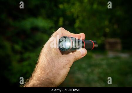 Mano che regge una piccola torcia LED nel profilo Foto stock - Alamy