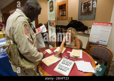 Austin Texas USA, gennaio 2012: Veterano militare degli Stati Uniti in pensione completa il cambio di indirizzo modulo in uno stand di registrazione per votare durante una fiera del lavoro al palazzo del Campidoglio del Texas. ©Marjorie Kamys Cotera/Daemmrich Photography Foto Stock