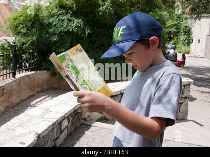 San Antonio Texas USA, gennaio 12 2012: Ragazzo ispanico di 7 anni legge la brochure informativa e la mappa allo zoo di San Antonio. Modello rilasciato © Marjorie Kamys Cotera/Daemmrich Photography Foto Stock