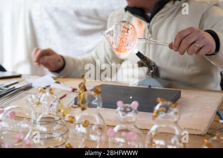 Artigiano decorazione di oggetti in vetro utilizzando una torcia. Foto Stock