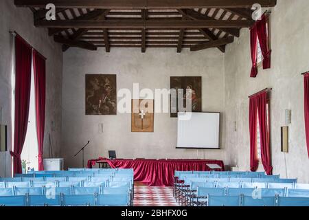 Vicenza, Italia - 13 maggio 2015: Sala conferenze con sedie blu tela e tende rosse, all'interno della villa Cordellina Lombardi. Foto Stock