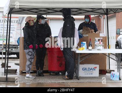 Frontenac, Stati Uniti. 25 Aprile 2020. I volontari della St. Louis Area Foodbank si accovattano in una tenda lontano dalla pioggia e dalle temperature a 60 gradi, mentre attendono le donazioni di cibo a Frontenac, Missouri, sabato 25 aprile 2020. La pandemia di coronavirus ha svuotato le dispense dell'alimento nella zona. Foto di Bill Greenblatt/UPI Credit: UPI/Alamy Live News Foto Stock