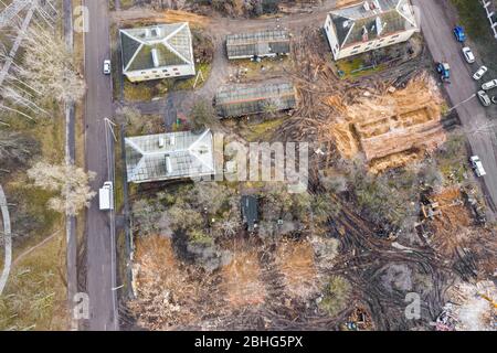 escavatore pesante che lavora nel sito di demolizione in rovine di vecchi edifici. foto drone aereo che guarda verso il basso Foto Stock