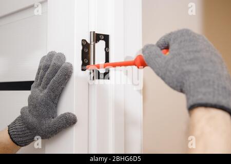 Carpentiere processo di installazione di legno porta cerniera Foto Stock