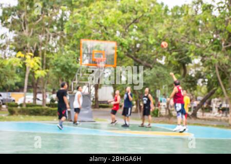 Immagini sfocate di uomini anziani e ragazzi giocare a basket in mattina a BangYai Park , Nonthaburi in Thailandia. Foto Stock