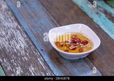 Salsa di pesce e pepe in una tazza sul tavolo. Foto Stock