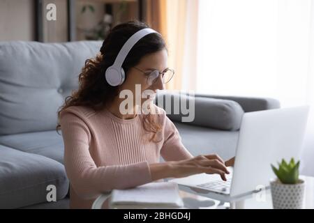 Felice studente donna millenaria in occhiali che studiano su corsi online. Foto Stock