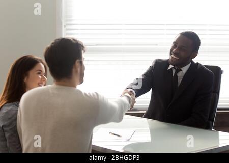 Felice uomo d'affari afro-americano che scuote le mani con l'uomo. Foto Stock
