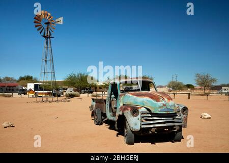 Old Chevrolet camion e mulino a vento, Solitaire, Namib deserto, Namibia, Africa Foto Stock