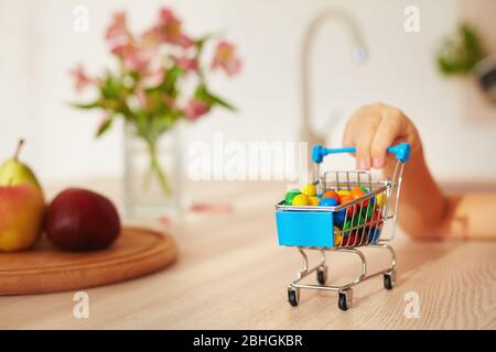 mini carrello pieno di caramelle sulla scrivania della cucina Foto Stock