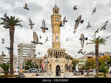 Gregge di piccioni che volano intorno alla Torre dell'Orologio di Izmir, in Turchia. Foto Stock