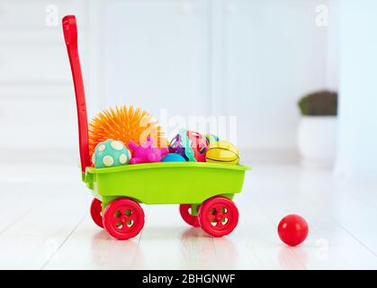 carrello giocattolo colorato pieno di diverse palle tattili per bambini Foto Stock