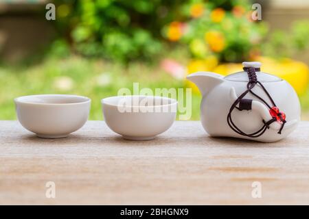 Man mano che versa il tè su tazza cinese del tè. Cultura tradizionale cinese degli utensili per cerimonie del tè tradizionale, Teacup cinese Foto Stock