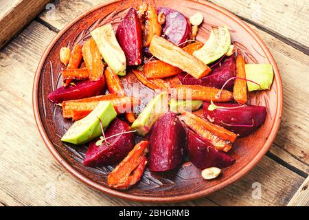 Insalata con carote caramellate, avocado, barbabietole e noci. Foto Stock