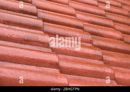 pioggia forte che cade sul tetto di tegole rosse a casa e che cade a terra Foto Stock