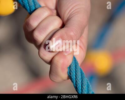 Mano tenere punto di Unione sulle corde in rete ragno, bambini playgound moderno a scuola. Foto Stock