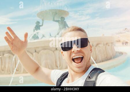 Valletta Malta felice turista uomo in bicchieri fa foto selfie sullo sfondo Triton fontana Foto Stock