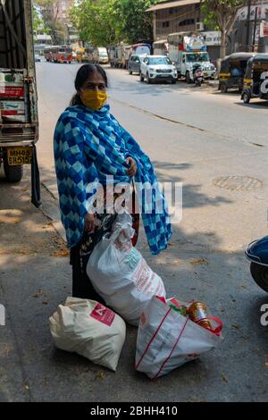 Mumbai / India 26 Marzo 2020 UNA Donna indiana che indossa una maschera protettiva che gating alimentari durante un 21 giorni di blocco a livello nazionale per limitare la diffusione di Foto Stock