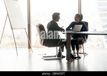 Due partner aziendali che discutono la strategia di progetto in un ufficio moderno Foto Stock