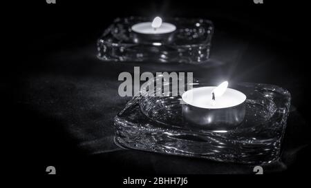 primo piano di due candele al buio, in bianco e nero Foto Stock