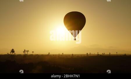 Mongolfiera all'alba di fronte alle montagne dell'Atlante vicino a Marrakech Foto Stock