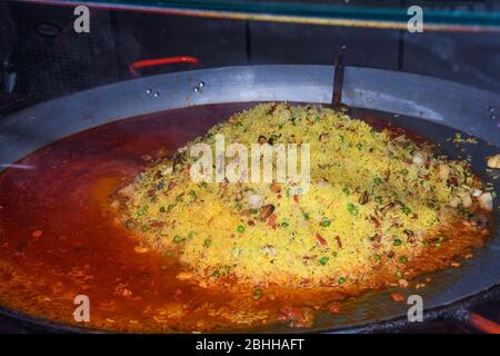 Paella di pesce cucinata in un grande padella wok, festa del cibo di strada. Specialità del piatto nazionale della festa messicana. Stazione di cottura dal vivo. Buffet di cibi freschi, Fr Foto Stock