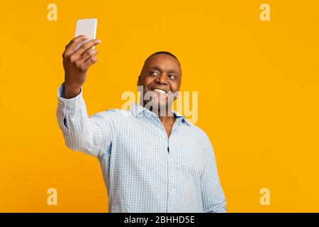 Bel nero maturo che fa selfie e sorridente Foto Stock