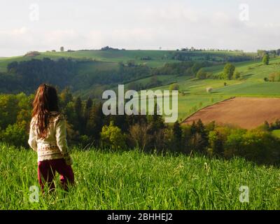 Bambina tra i 6 e gli 8 anni vista da dietro guardando in salita Foto Stock