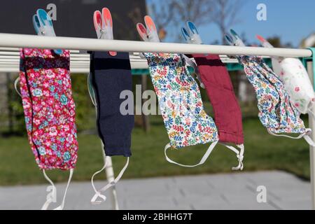 maschera facciale fatta a mano appesa sulla linea dei vestiti dopo il lavaggio Foto Stock