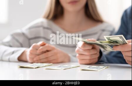 Giovani famiglie che contano poveri risparmi in casa, primo piano Foto Stock