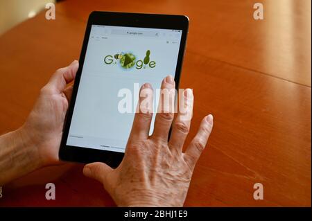 Una donna senior fa riferimento a google su Internet con il suo iPad tablet. Foto Stock