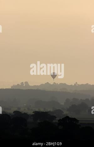 Mongolfiera che viaggia attraverso le pianure del Cheshire visto da Borras Head, Wrexham Foto Stock
