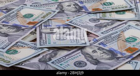 Molte centinaia di banconote da dollari sono sparse intorno alla scrivania dell'ufficio. Il concetto di ricchezza e di successo del business. Foto Stock