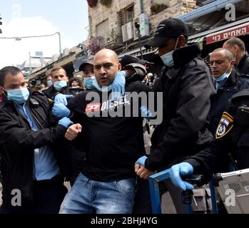 Gerusalemme, Israele. 26 aprile 2020. La polizia israeliana arresta un venditore del famoso mercato all'aperto Mahane Yehuda, durante una protesta contro la chiusura estesa del mercato, mentre il governo israeliano ha allentato le restrizioni di coronavirus per altre imprese, lunedì 26 aprile, a Gerusalemme. I manifestanti hanno bandito i pans e gridato contro l'apertura di IKEA, mentre sono costretti a rimanere chiusi. Foto di Debbie Hill/UPI Credit: UPI/Alamy Live News Foto Stock