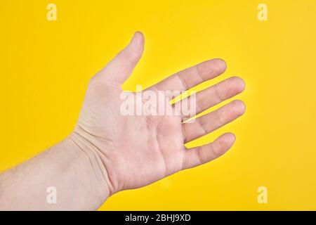 Palmo aperto isolato su sfondo giallo. Primo piano Foto Stock