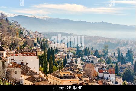 Paesaggio pittoresco paesaggio vista città di Granada località tetto cime di case residenziali e vista valle lontano per innevare le montagne della Sierra Nevada Foto Stock