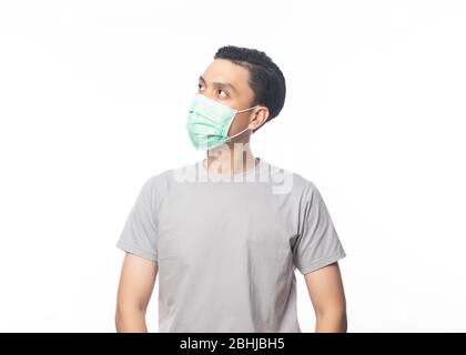 Giovane asiatico uomo che indossa la maschera igienica e che cerca di copyspace per prevenire l'infezione, 2019-nCoV o coronavirus. Malattia respiratoria veicolata dall'aria come il pm Foto Stock