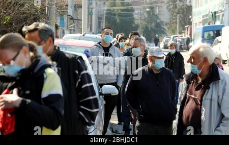 Belgrado, Serbia. 10 aprile 2020. Le persone con maschera facciale protettiva attendono in fila per entrare nell'ufficio postale durante la pandemia in corso della malattia COVID-19 causata dal coronavirus SARS-cov-2. Foto Stock