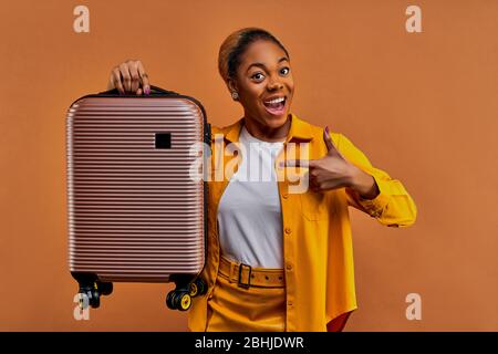 Signora con sorriso con orecchini con bagaglio direttamente a sinistra Foto Stock