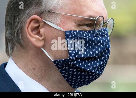 26 aprile 2020, Sassonia-Anhalt, Halle (Saale): Reiner Haseloff (CDU), primo ministro della Sassonia-Anhalt, indossa una maschera facciale con piccoli fiori dopo una conferenza stampa presso lo zoo di montagna di Halle/Saale. In precedenza, i due capi di governo della Sassonia e della Sassonia-Anhalt avevano discusso l'ulteriore via da seguire per affrontare la pandemia della corona. Essi hanno detto che avrebbero valutato congiuntamente quali opzioni di allentamento e apertura fossero concepibili e come il rischio potesse essere valutato in considerazione dell'attuale situazione di infezione. Foto: Hendrik Schmidt/dpa-Zentralbild/dpa Foto Stock