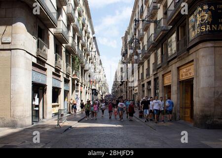 Vista delle persone che camminano su una delle strette vie dello shopping chiamata 'Carrer de Ferran' nel quartiere 'Ciutat Vella' (quartiere Gotico) di Barcellona. Lo è Foto Stock