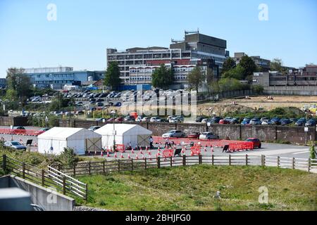 Watford, Regno Unito. 26 aprile 2020. Watford General Hospital (sullo sfondo) e un centro di test che ha aperto nel parcheggio il 23 aprile (indicato come due tende bianche). I soggetti idonei a utilizzare il centro di test sono i membri del personale ospedaliero o la loro famiglia che sono sintomatici del Covid 19. Per accelerare il programma di test verso un obiettivo di 100,000 test al giorno entro il 30 aprile stabilito da Matt Hancock, Segretario della Sanità, negli ultimi giorni sono stati allestiti molti altri centri di test, compresi i centri di test mobili a comparsa. Credit: Stephen Chung / Alamy Live News Foto Stock