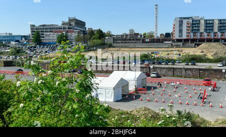 Watford, Regno Unito. 26 aprile 2020. Watford General Hospital (sullo sfondo) e un centro di test che ha aperto nel parcheggio il 23 aprile (indicato come due tende bianche). I soggetti idonei a utilizzare il centro di test sono i membri del personale ospedaliero o la loro famiglia che sono sintomatici del Covid 19. Per accelerare il programma di test verso un obiettivo di 100,000 test al giorno entro il 30 aprile stabilito da Matt Hancock, Segretario della Sanità, negli ultimi giorni sono stati allestiti molti altri centri di test, compresi i centri di test mobili a comparsa. Credit: Stephen Chung / Alamy Live News Foto Stock