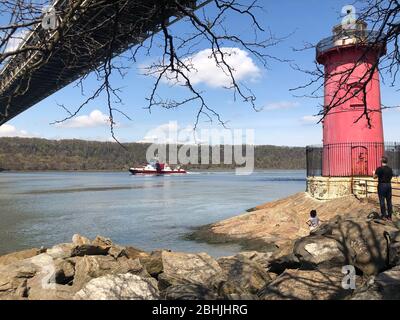 New York, Stati Uniti. Aprile 2020. Il reparto antincendio di New York è in corso sul fiume Hudson sotto il ponte George Washington dal faro piccolo rosso. Jeffr Foto Stock