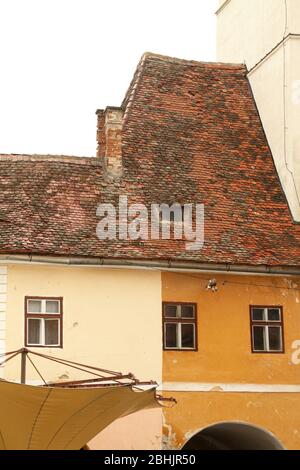 Sibiu, Romania. Casa sassone del XV secolo con tetto in tegole, collegata alla Torre del Consiglio (Turnul Sfatului), vista dalla Piazza Grande (Piata Mare). Foto Stock