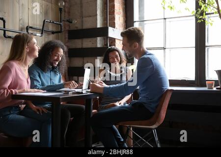 Sorridenti amici multietnici divertirsi a studiare in caffè insieme Foto Stock