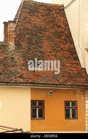 Sibiu, Romania. Casa sassone del XV secolo con tetto in tegole, collegata alla Torre del Consiglio (Turnul Sfatului), vista dalla Piazza Grande (Piata Mare). Foto Stock