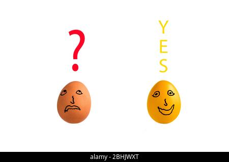 Due uova di pollo, una dorata su sfondo bianco con domanda e si sopra le uova. Concetto: Rivelazione, ispirazione, epifania, genio. Foto Stock