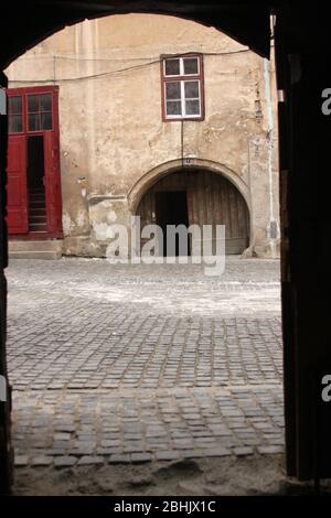 Sibiu, Romania. Case sassone nella Città Vecchia collegate per formare una fortificazione, con passaggi per i tribunali interni. Strade acciottolate originali. Foto Stock